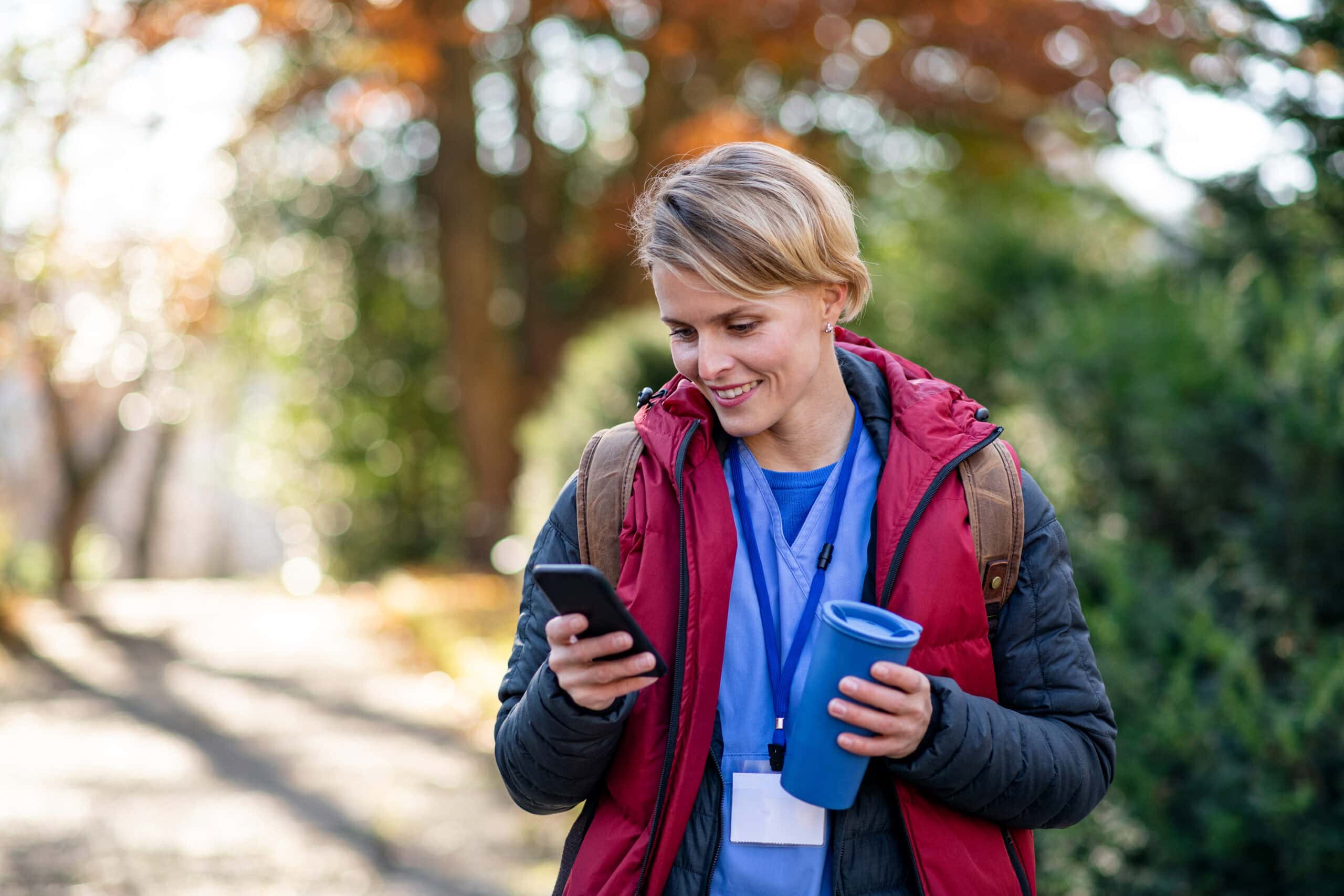 a nurse outside looking at her smart phone
