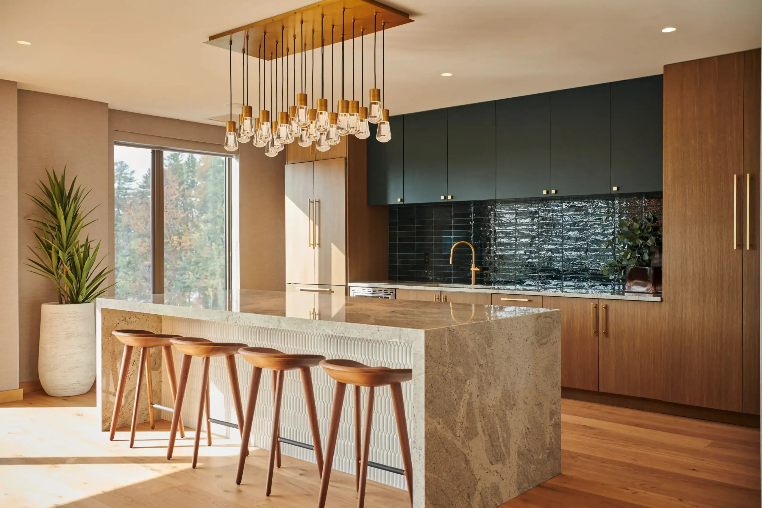 Modern community kitchen with oversized island, bar seating, designer lighting, and premium finishes.