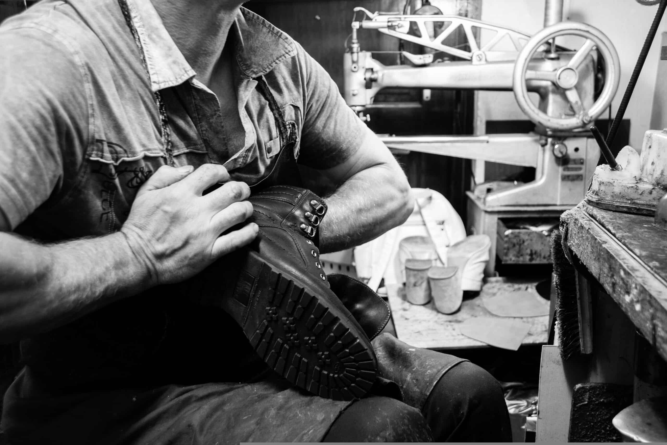 Handwerker fertigt Lederschuh in Werkstatt, Detailaufnahme, Schwarz-Weiß.