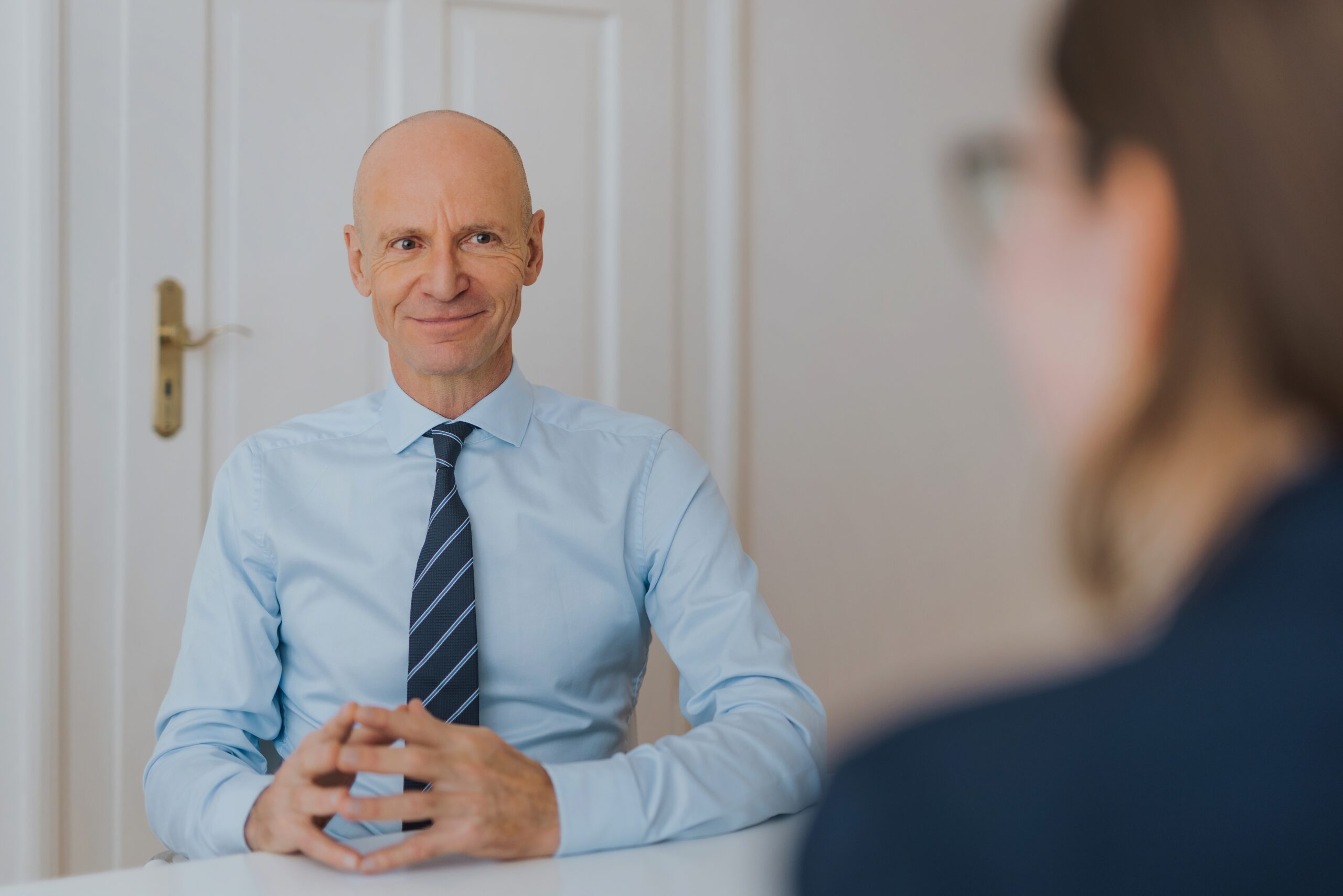 Dr. Gerd Kommer im Beratungsgespräch mit einer Person, die lediglich von hinten zu sehen ist.