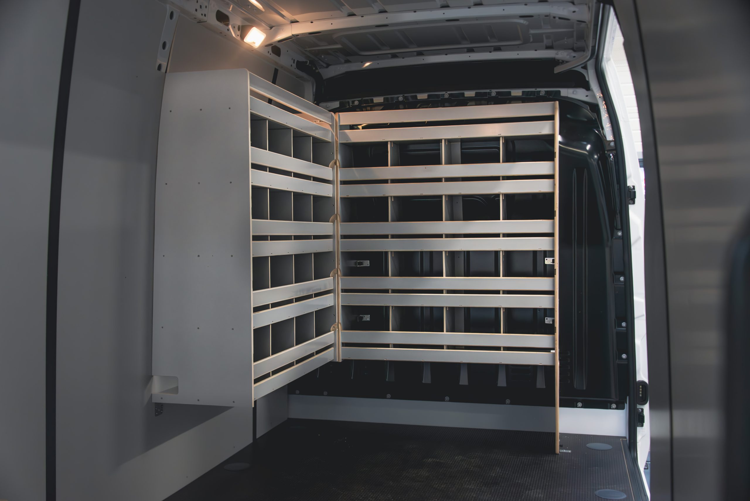 Intérieur d’un utilitaire avec étagères en bois et casiers techniques installés