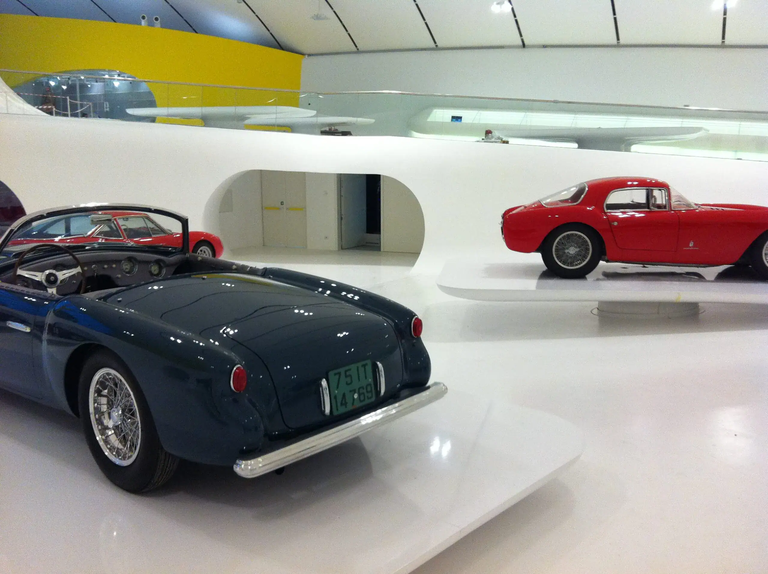 MEF Museo Enzo Ferrari a Maranello con pavimento in resina bianca lucida Prima Pavimenti — rivestimento decorativo autolivellante ad alta riflessione luminosa per ambienti museali di prestigio con esposizione di vetture storiche