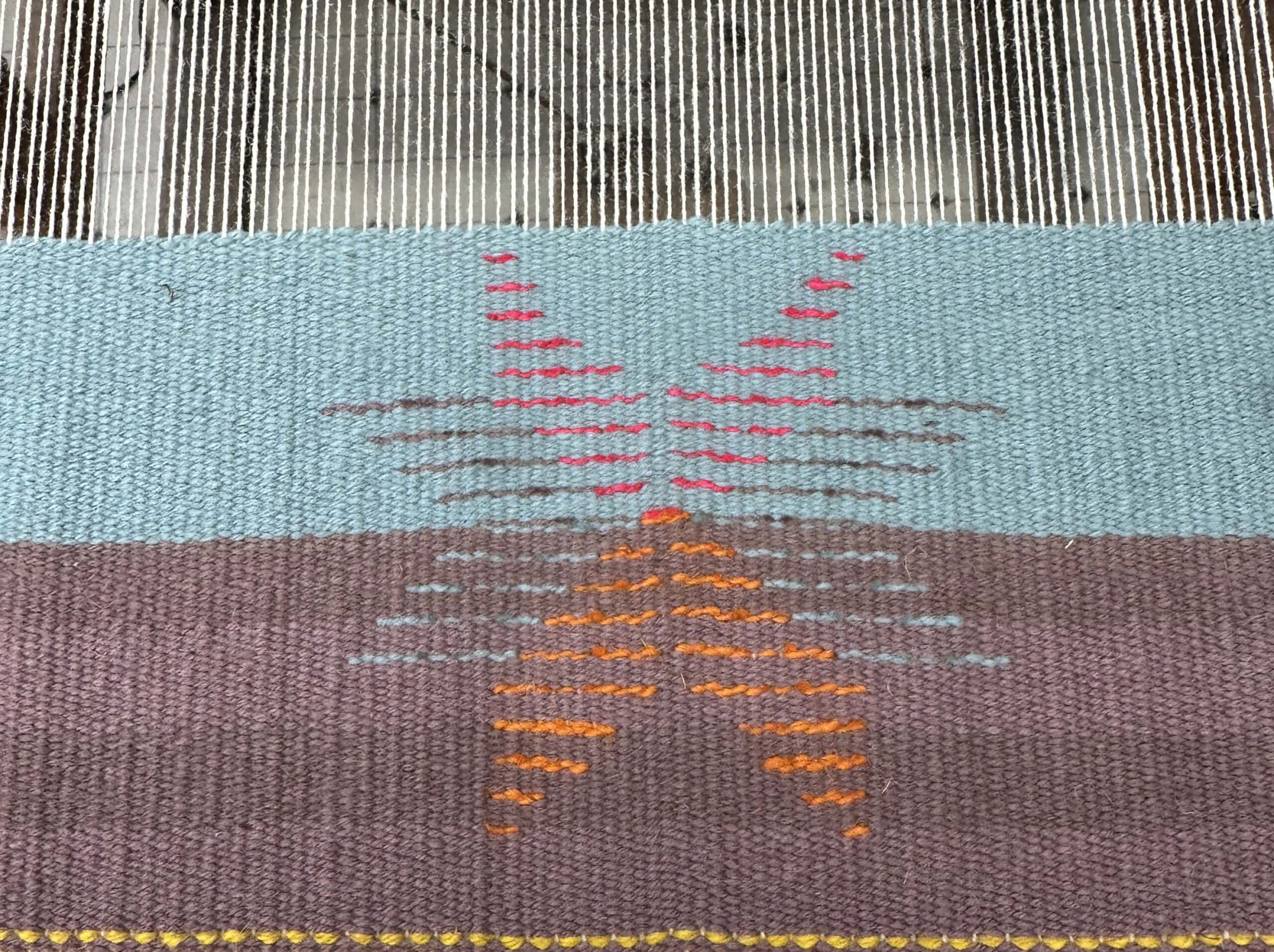a woven piece on the loom featuring a star