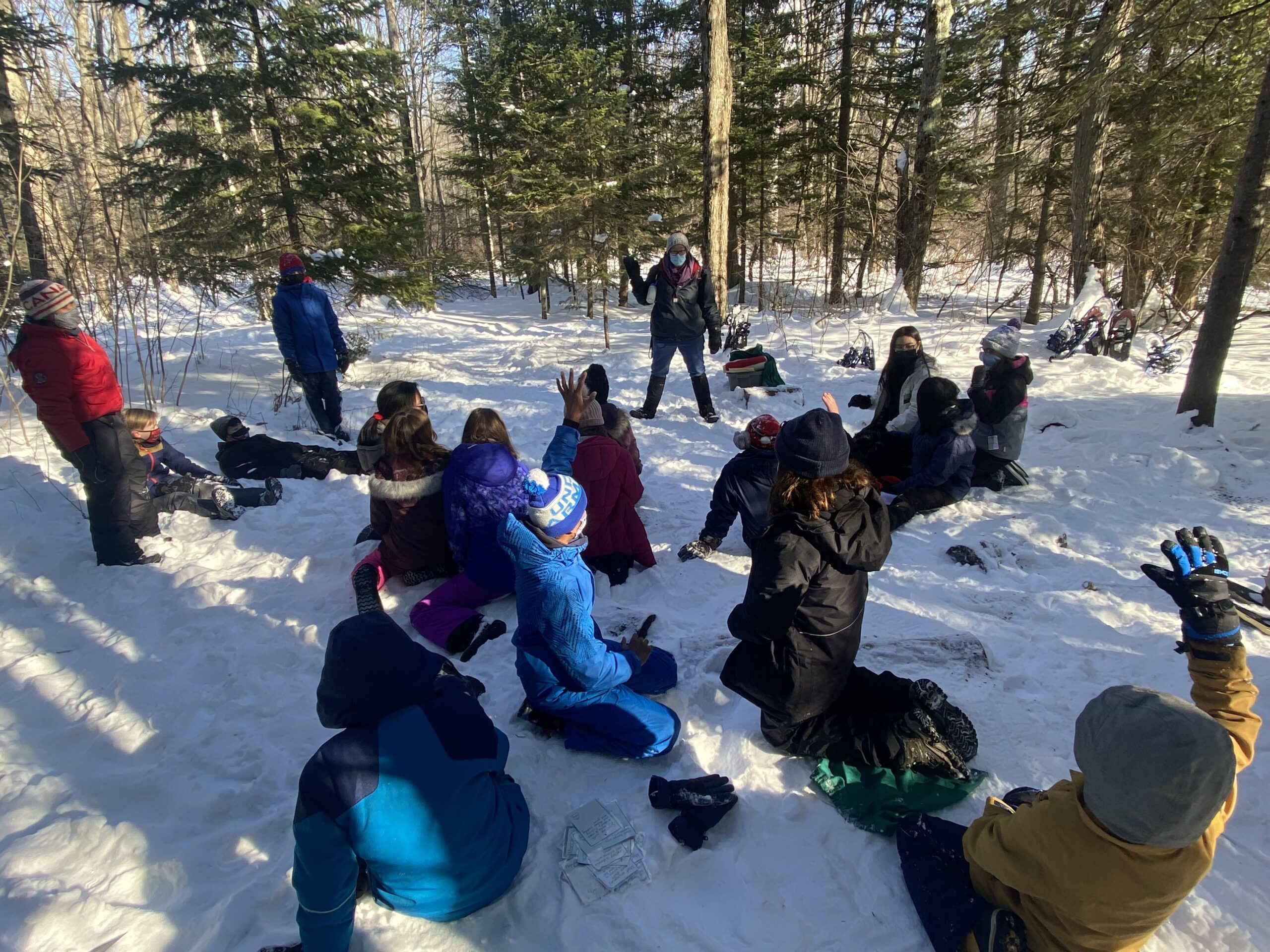 Students sitting in a forest in the snow | Bishop Hamilton Montessori School in Ottawa