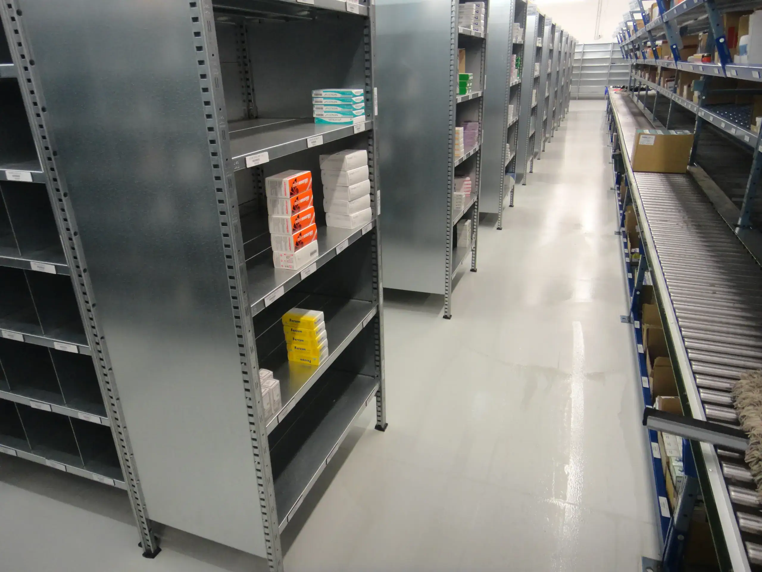 Magazzino farmaceutico Alleanza Salute con pavimento in resina epossidica Prima Pavimenti — rivestimento antistatico ESD resistente a solventi farmaceutici, facile da sanificare e conforme alle norme GMP per la distribuzione di medicinali