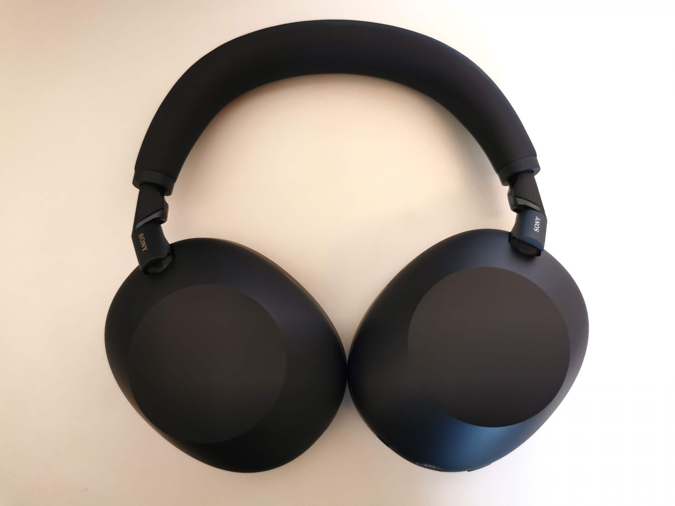 Sony WH-1000XM6 with earcups folded flat, showing the new wider headband and smooth earcups, over a white background.