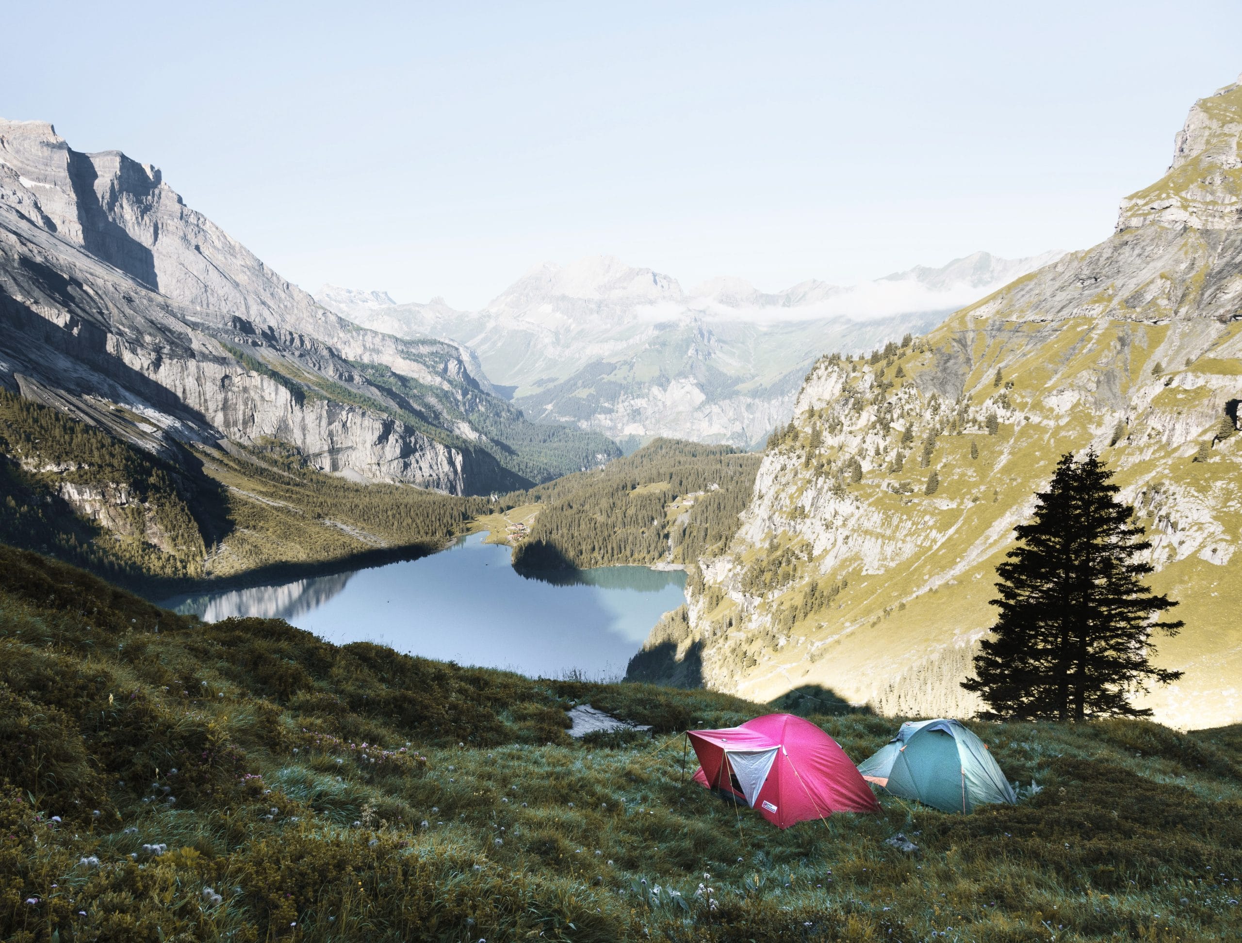 best summer mountain vacations for families blog cover: Tents in front Kandersteg lake
