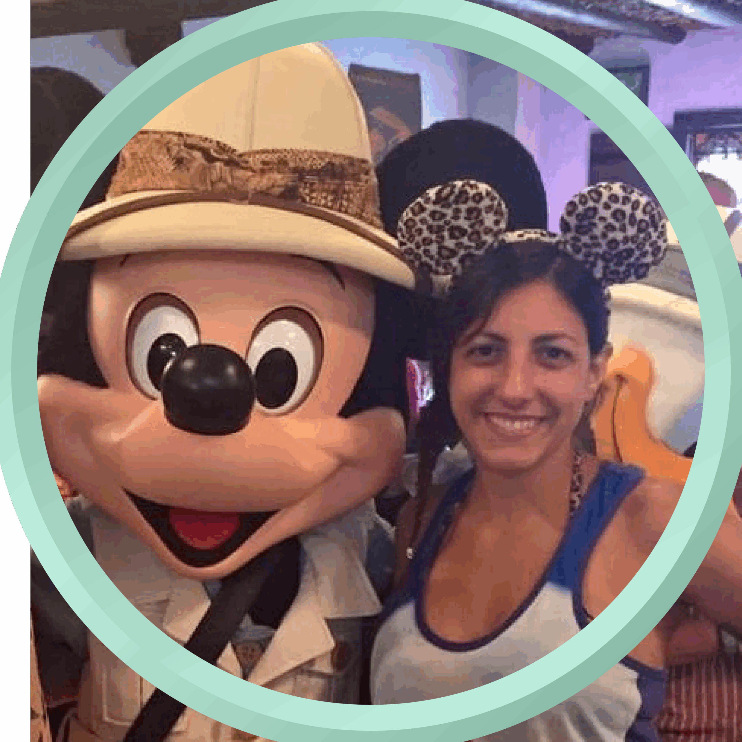 Mickey Mouse with a woman wearing leopard print Minnie ears at a Disney destination.