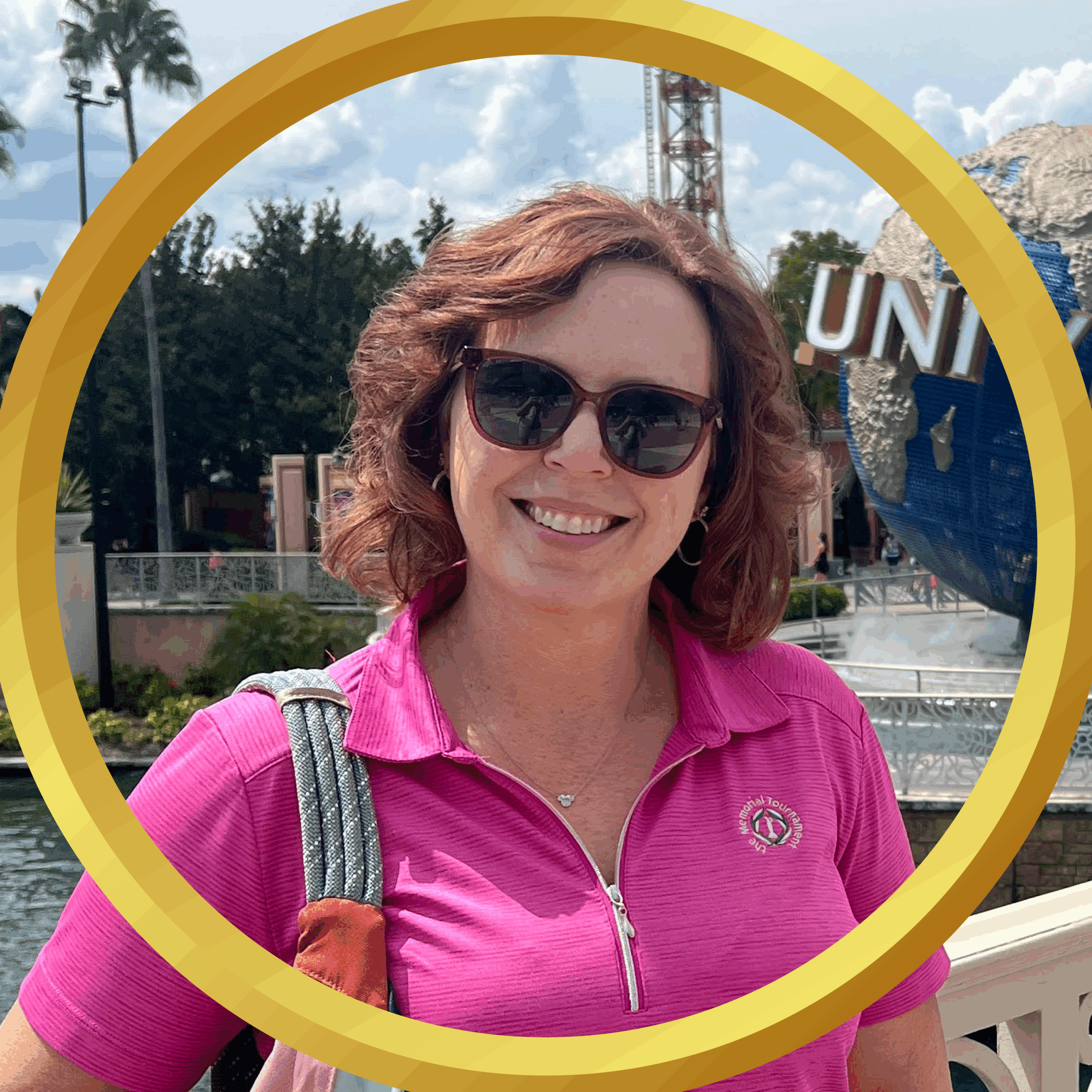Smiling woman in pink shirt at Universal Studios Orlando themed park.