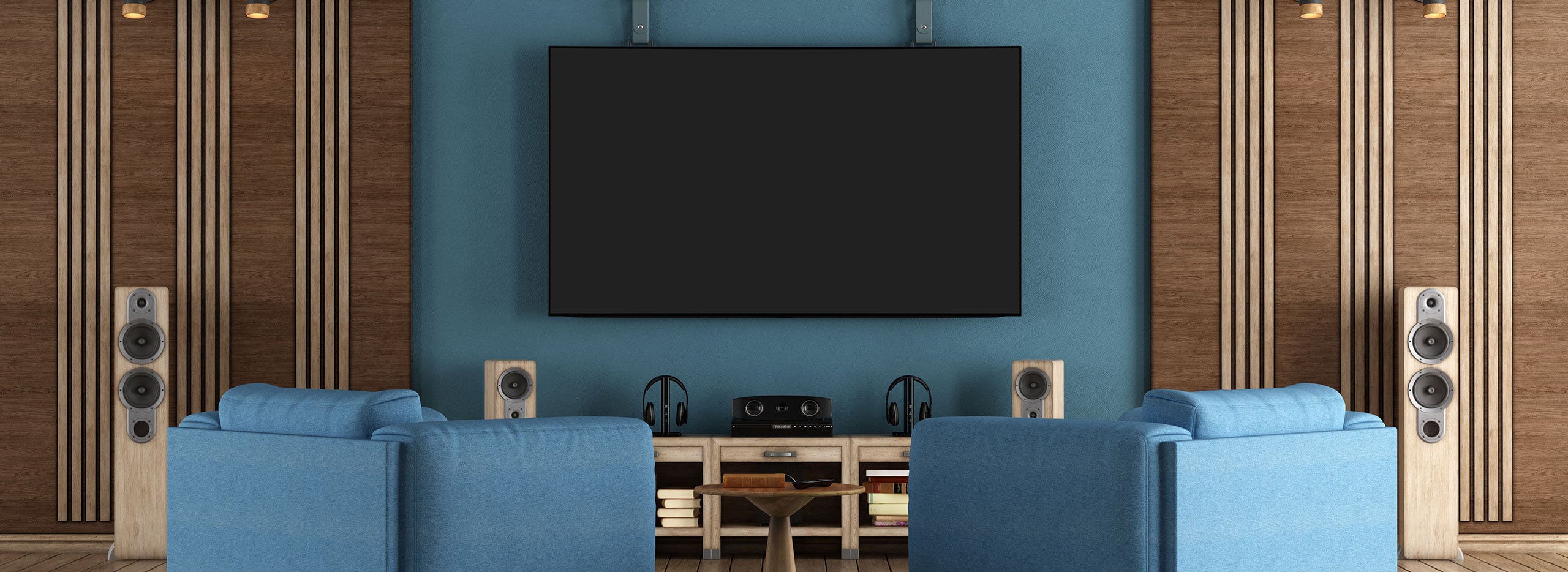 Wohnzimmer mit großem Bildschirm, zwei blauen Sesseln und hochwertigen Lautsprechern. Symbolbild für das Thema Heimkino.