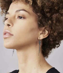 Photo of model wearing diamond and oxidised silver chain earrings.