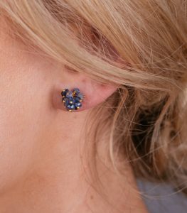 Blue sapphire cluster stud earrings on a model