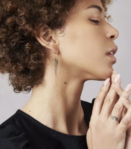 Photo of model wearing sapphire and gold earrings.