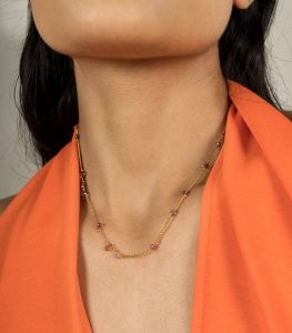 Necklace with spinel beads on gold-plated silver chain, won by a model in an orange top