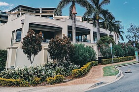 photo of palm trees and flowers near a building