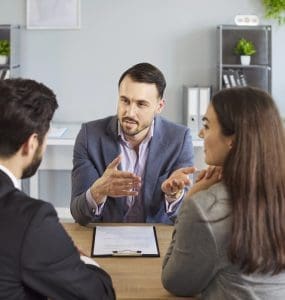 image of couple meeting with lawyer for a post about 10 reasons why aspiring franchisees need a franchise attorney