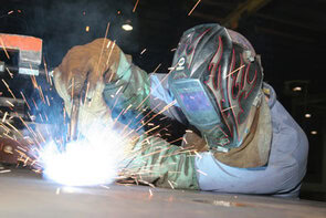 Image of a welder in a shop MIG welding