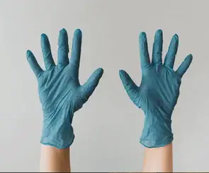 Two hands in the air with blue gloves representing contimation OCD. Start OCD counseling and ERP in Detroit, mi