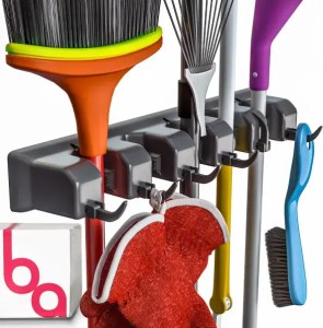 Brightly colored cleaning tools hung on a wall rack, including brooms, dusters, and scrub brushes, ideal for home organization and cleaning routines.