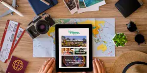 Vegan travel planning setup with map, passport, camera, and tablet showing vegan travel guides