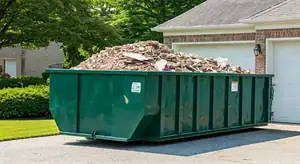 20-yard dumpster on a driveway filled with debris