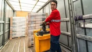 Latin man worker loading a delivery truck in distribution warehouse