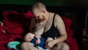 hombre trans amamantando artificialmente a bebé