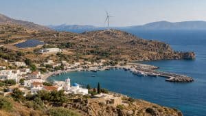 Île grecque avec village côtier, éolienne, panneaux solaires et installation de stockage électrique
