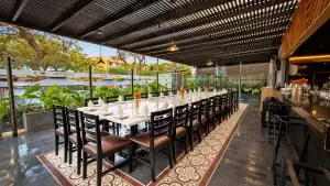 Terraza Alta de La Vaca Loca en Miraflores con mesa larga montada para una reunión de planeamiento, techo de listones de madera y barra