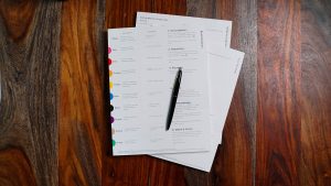 Bureau avec ordinateur portable et checklist de conformité, illustrant les obligations d'assurance d'un employeur en France