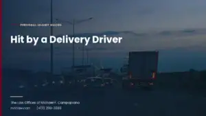 A box truck traveling with traffic on a multi-lane highway at dusk
