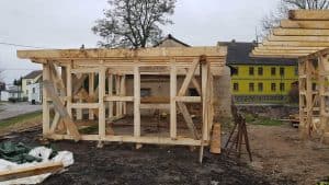 Geringes Geheimnis: Die Antwort befindet sich auf dem zweiten Bild. Es zeigt den Bau einer Holzterrasse auf dem Grundstück der Wellnesshof RaJa in Deutschland, mit Fokus auf Naturnähe und entspannendes Ambiente.