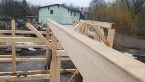 Holzrahmen für Bauprojekt auf dem Wellnesshof RaJa, natürliche Materialien, hochwertige Handwerkskunst, nachhaltiges Bauvorhaben, idyllische Umgebung, Holzarbeiten im Fortschritt, ruhige ländliche Lage, naturverbundenes Wohnen, umweltfreundliche Bauweise, ländlicher Baustil.