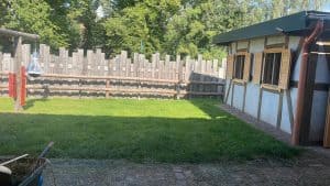 Gemütlicher Garten mit Holzsitzgatter und Hühnerstall auf dem Wellnesshof RaJa.