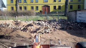 Baustelle auf dem Wellnesshof RaJa, Abbrucharbeiten im Außenbereich, vorbereitende Erdarbeiten für Renovierung, Bauarbeiten in vollem Gange, aktueller Zustand des Gebäudes im Hintergrund.