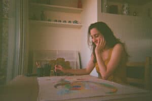 Valentina Bartolini painting in her studio, working on a surrealist pastel piece from her Studio Meditation collection.