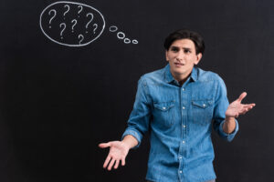 A stressed out young man with question marks coming out of his head who is trying to figure out "how to stop drinking".