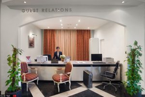 Профессиональное фото зоны Guest Relations в гостинице с сотрудником и чемоданом