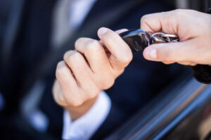 One hand giving car keys to another hand.