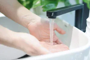 Hands being washed under a running tap in a sink image. Nhe time is now to start OCD counseling in Detroit
