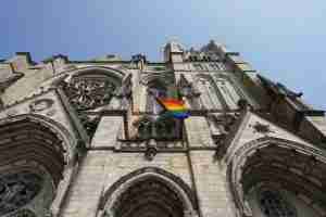a rainbow flag is hanging on the side of a church reflecting themes of introspection and healing through LGBT therapy in Ann Arbor, MI.