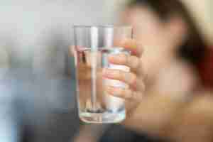 person holding clear drinking glass. Want to start anxiety treatment in Ann Arbor, MI? Speak with a compassionate anxiety therapist to get started on your healing journey.