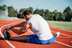 man in white sleeveless top streching carrying life experiences while progressing with support from a complex PTSD therapist near me in Farmington Hills, MI.