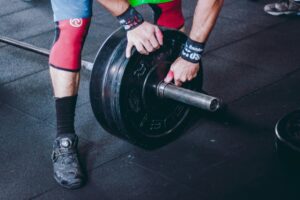 Atleta che prepara il bilanciere per svolgere una sessione di allenamento di strength and conditioning seguendo la programmazione offerta da Fisiart Biasca