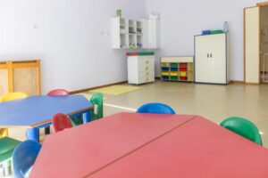 Aula de Educación Infantil vacía con mesas y sillas de colores, imagen de recurso
