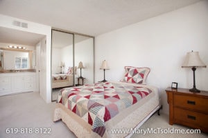 Primary bedroom at 4205 Ohio Street featuring mirrored closet doors, neutral carpeting, and an en suite bathroom with a white vanity.
