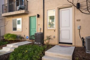 Modern exterior and front entrance of 5235 Beachfront Cove Unit 102 in the Playa Del Sol community, showcasing a private walkway