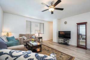 Spacious living area at 5235 Beachfront Cove Unit 102 with upgraded ceiling fans and custom vinyl blinds.