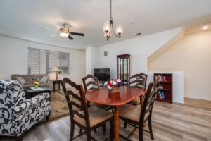 Open-concept dining area at 5235 Beachfront Cove Unit 102 featuring designer lighting and a seamless flow into the main living room area