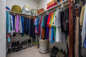 Large walk-in closet in the primary suite of 5235 Beachfront Cove Unit 102, featuring extensive shelving and hanging space for organized storage.